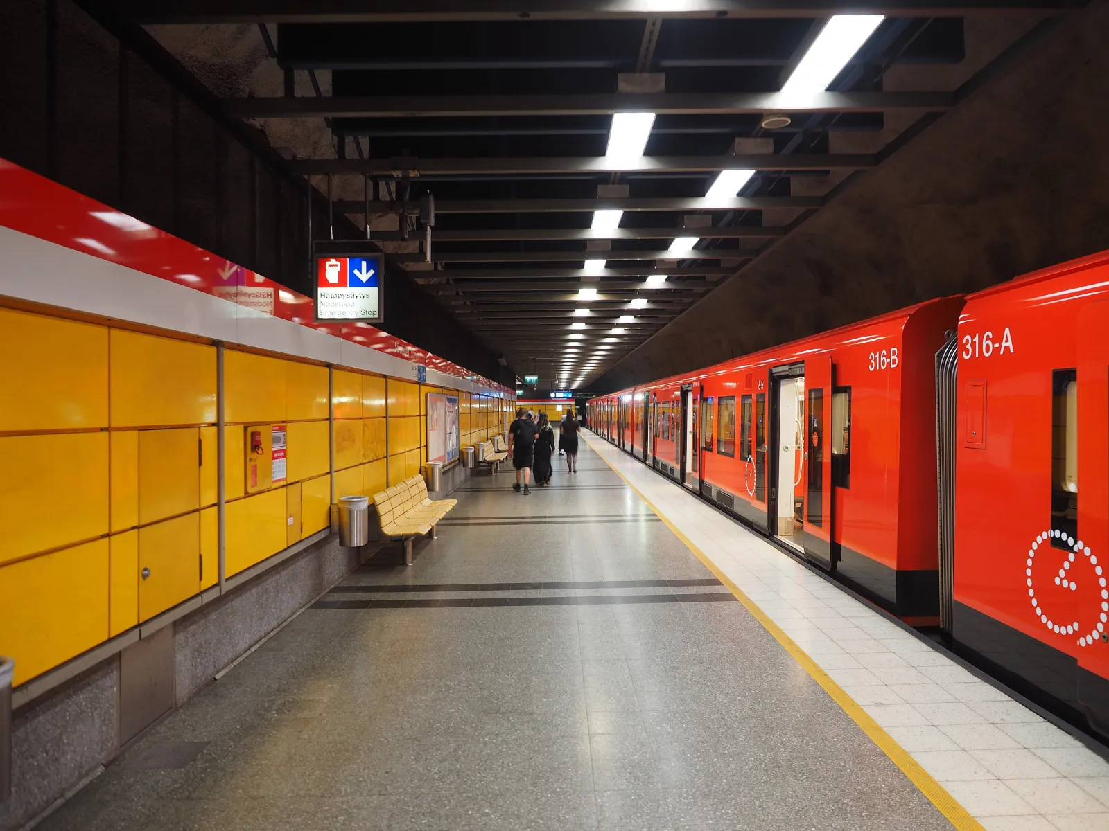 An orange Helsinki metro train waiting at the platform at Sörnäinen station