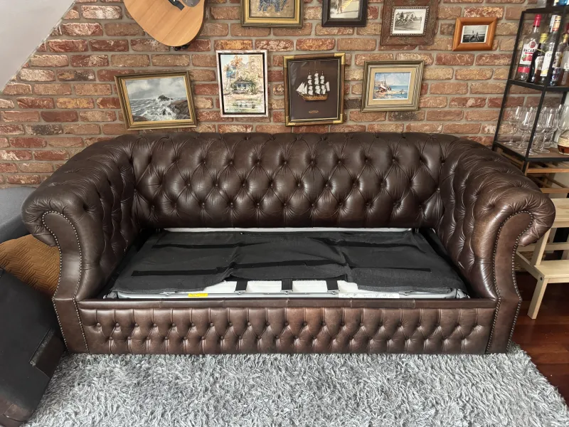 The sofa with its seat cushions removed, showing the folded frame