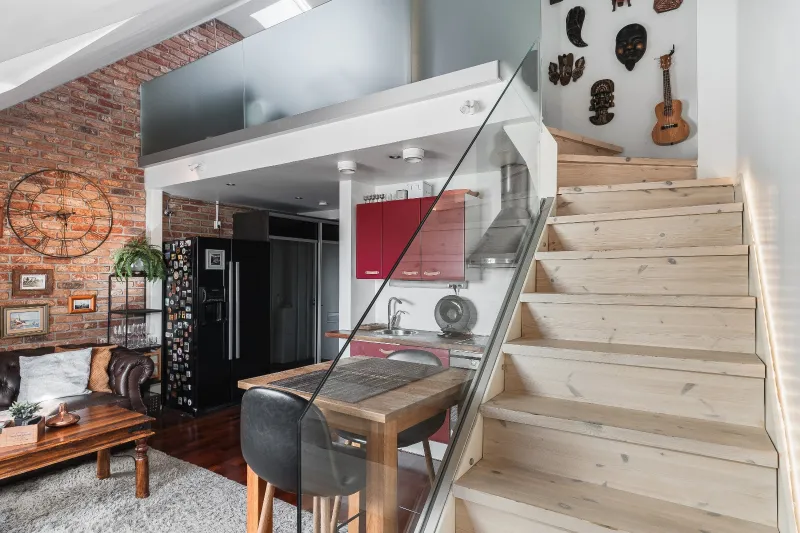 Pine staircase with glass balustrade rising to the mezzanine